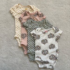 Four Newborn sized floral onesies.  Minimally worn.